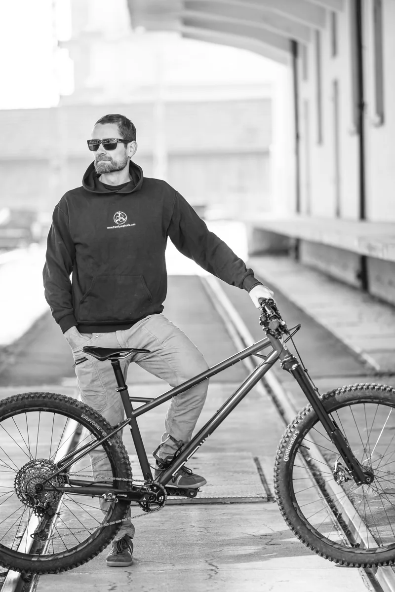 Black-and-white portrait of Sam with a RAIL bicycle