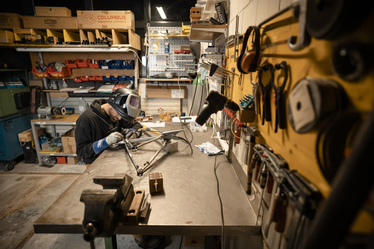 Sam working on a bicycle frame at the workbench